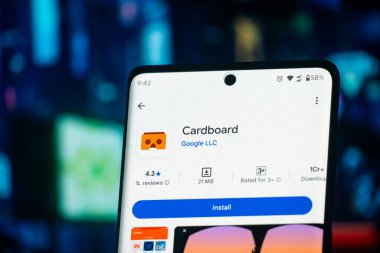 Dhaka, Bangladeş 26 Aralık 2025: Google Karton uygulamasını kablosuz kulaklıkların yanında indirmeye hazır olarak gösteren telefon