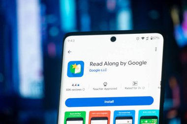 Dhaka, Bangladeş 07 Aralık 2025: Kulaklıkların yanında ekranı Google uygulamasının Read Along ile birlikte kurduğu akıllı telefon