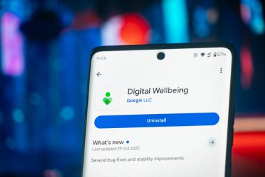 Dhaka, Bangladeş 26 Aralık 2025: Bir çift kulaklık yakınındaki Dijital Refah uygulamasını açma seçeneğini gösteren akıllı telefon ekranı