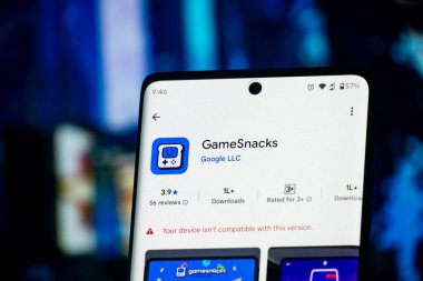 Dhaka, Bangladeş 26 Aralık 2025: Mavi arka planda siyah kulaklıklı akıllı telefon ekranı GameSnacks uygulaması