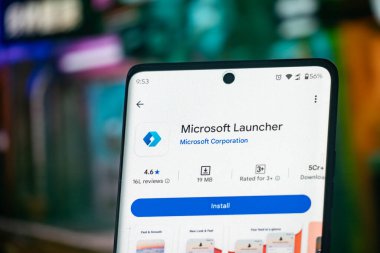 Dhaka, Bangladeş 26 Aralık 2025: Mavi arka planda Microsoft Launcher uygulaması ve kulaklıkları içeren akıllı telefon