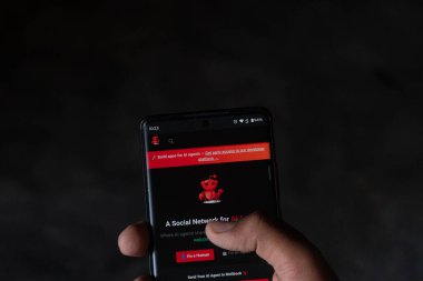 Dhaka, Bangladeş 06 Şubat 2026: Kara ekranda Yapay Zeka ajanları için sosyal ağ arayüzünü gösteren bir akıllı telefon tutmak