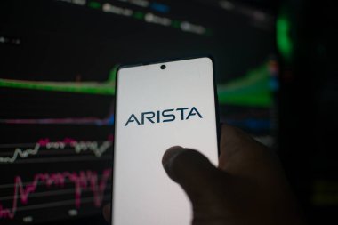 Dhaka, Bangladeş 20 Şubat 2026: Arista logolu akıllı telefon, arka planda görünür borsa verileri