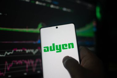 Dhaka, Bangladeş 20 Şubat 2026: Adyen logosunu hisse senedi arkaplanında gösteren telefon