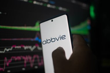 Dhaka, Bangladeş 20 Şubat 2026: Abbvie 'yi bir arkaplan borsa grafiklerine karşı gösteren akıllı telefon veri analizi öneriyor
