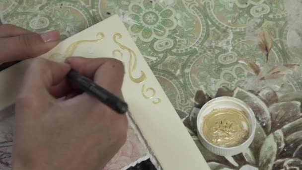 La ragazza disegna la vernice d'oro di ornamento su una struttura di legno — Video Stock