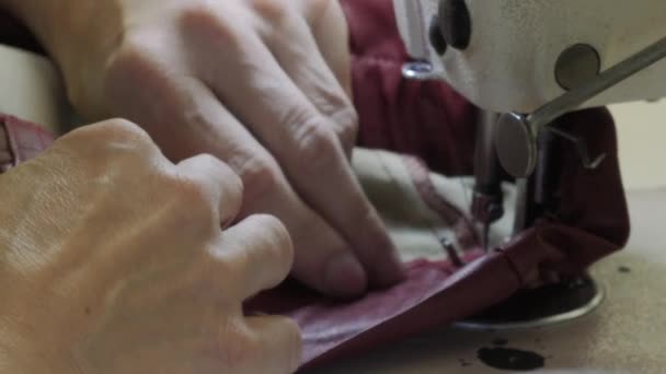 Una costurera trabaja en una máquina de coser industrial. — Vídeos de Stock