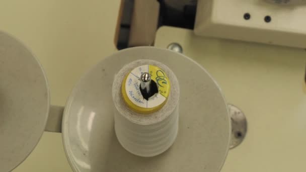 En tråd på en spole i en symaskin för industriellt bruk. — Stockvideo