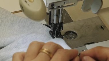 Bir terzi endüstriyel dikiş makinesinde çalışır..