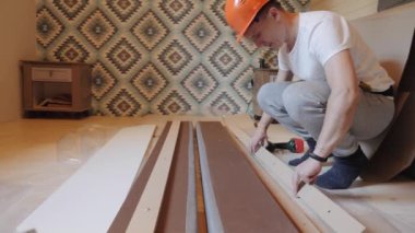 Bir işçi yatak odasına yatak yapar.