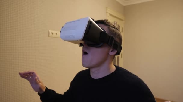 Mannen sätter på sig VR-glasögon och är förvånad. — Stockvideo