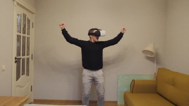 Der Mann setzt sich eine VR-Brille auf und staunt. — Stockvideo