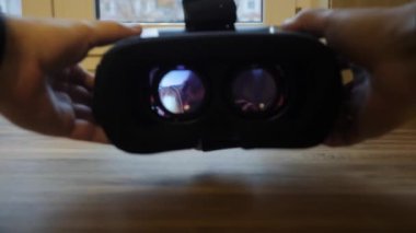 Erkekler sanal gerçeklik gözlüklerini masaya koyarlar..