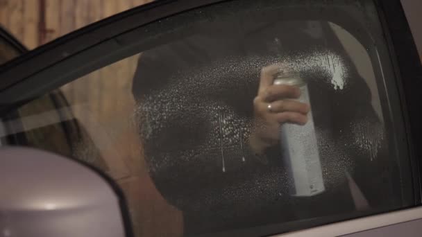 A man wipes the car window with a cleaning disinfectant. — Stock Video