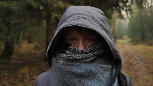Portret van een meisje in winterkleding die haar gezicht verbergt met een sjaal. — Stockvideo