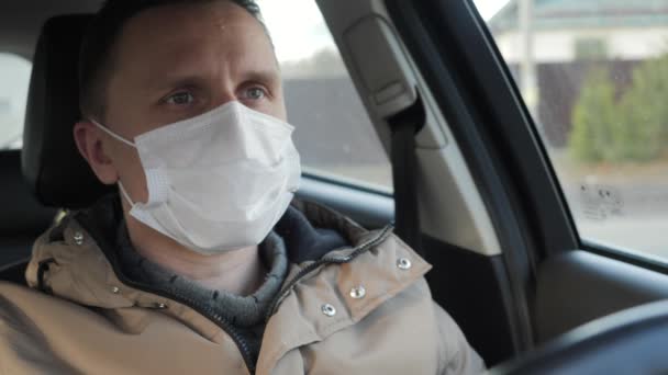 Um homem no carro remove uma máscara médica.. — Vídeo de Stock