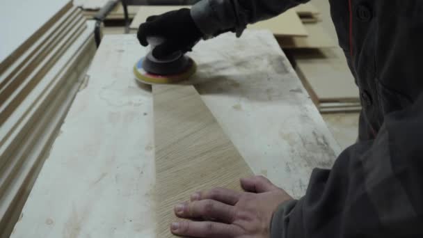 Un trabajador de la industria del mueble muele productos de madera con una amoladora. — Vídeos de Stock