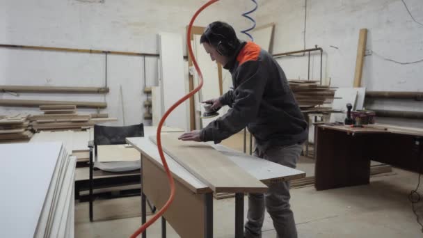 Un trabajador de la industria del mueble muele productos de madera con una amoladora. — Vídeos de Stock