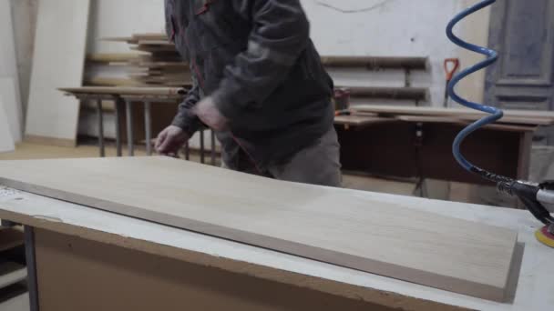 Un trabajador de la industria del mueble muele productos de madera con una amoladora. — Vídeos de Stock