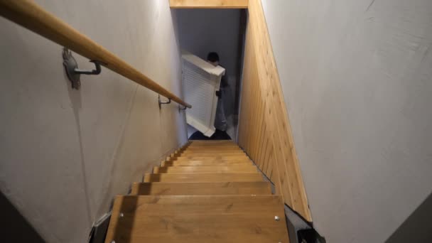 Un homme soulève des meubles dans les escaliers — Video