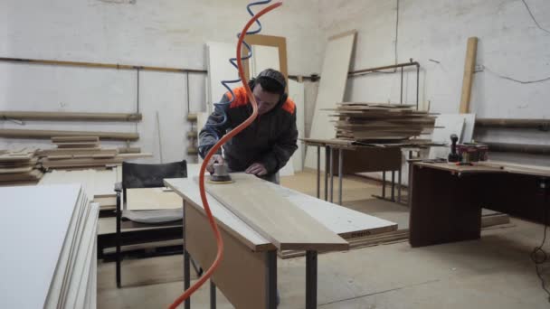En arbetare inom möbelindustrin slipar träprodukter med en kvarn. — Stockvideo