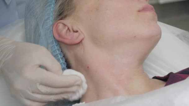 Lékař podá pacientovi injekci botoxu do krku. — Stock video