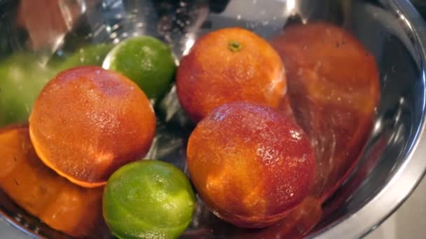 A large metal bowl filled with oranges and limes. — Stock Video