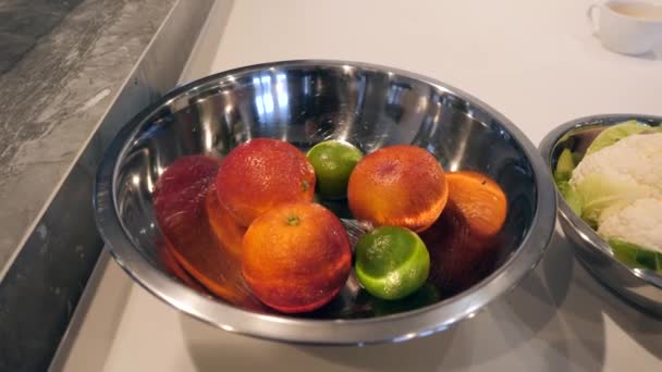 A large metal bowl filled with oranges and limes. — Stock Video