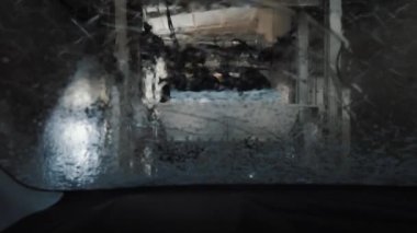 Araba, araba yıkama tünelinden geçiyor.