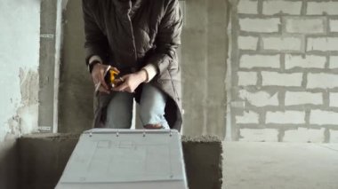 Tasarımcı kız tadilata başlamadan önce odanın ölçülerini alıyor..