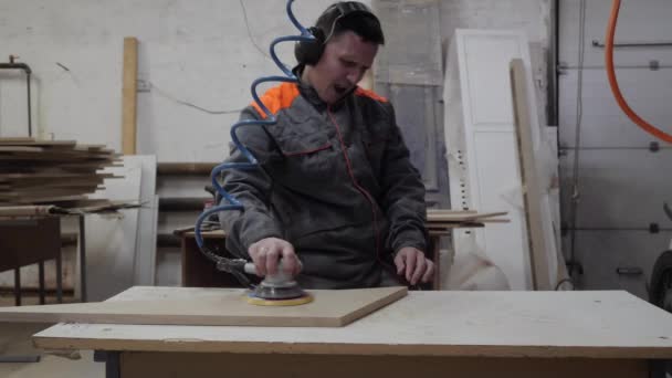 Ένας εργαζόμενος στη βιομηχανία επίπλων αλέθει προϊόντα ξύλου με μύλο. — Αρχείο Βίντεο