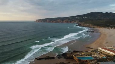 Hava manzaralı sahil sahili, dalgalar ve tatil köyü havuzu, sakin sabah ışığı, dalgalı sörf toplantısı kumlu sahil.,