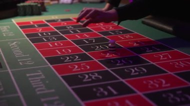 Beyaz Oyuncu Rulete Fiş Yerleştirdi, Yakın plan Yeşil Keçeli, Kırmızı ve Siyah Rakamlar Görünür, Odaklanmış Eller, Düşük Odaklanma