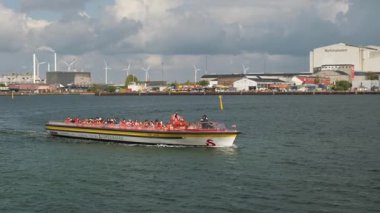 Gezgin Tekne Yolcularla Dolu Bulutlu Gök Altında Endüstriyel Liman Turuncu Can Yelekleri Görünür,