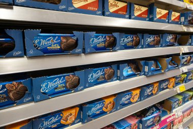 UYARI, POLAND - 20 HAZİRAN 2026: Çeşitli E. Wedel çikolataları ile dolu raflar, koyu% 64, ekstra koyu% 80 ve mavi ambalajda süt çikolata çeşitleri içeren mağazalar.