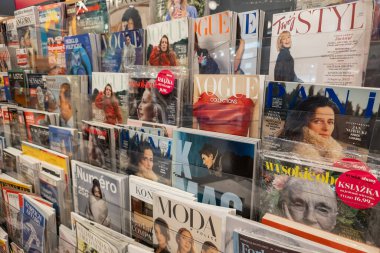 WARA, POLAND - 5 Ocak 2026: Bir basın mağazasında çeşitli moda ve yaşam tarzı dergileriyle dolu bir sergi rafı. Görünür başlıklar arasında Vogue, Twoj Styl, Pani, Wysokie Obcasy Extra ve K Mag sayıları bulunmaktadır.