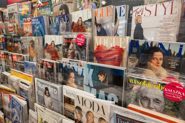 WARA, POLAND - 5 Ocak 2026: Bir basın mağazasında çeşitli moda ve yaşam tarzı dergileriyle dolu bir sergi rafı. Görünür başlıklar arasında Vogue, Twoj Styl, Pani, Wysokie Obcasy Extra ve K Mag sayıları bulunmaktadır.