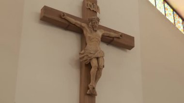 El oyması ahşap haç İsa 'yı kilise duvarında resmediyor. Statik çekim.