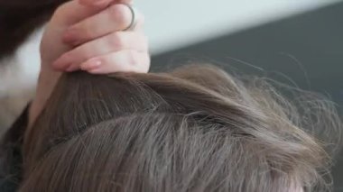 Uzatma işlemi için bir stilistin eline yüzük kesikli saçla aşırı yakın çekim.