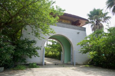 Jocheon 'daki Buda Sharira Stupa kompleksine yaklaşan çift kemerli tapınak kapısı, bir çadır ve tabelasını taçlandıran ağaçlarla gölgeleniyor..