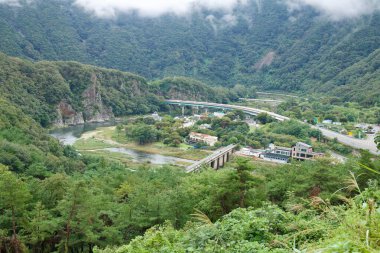 Gomo Dağı Kalesi 'nden geniş bir manzara Yeong Nehri' nin Jinnamgyoban at nalı kıvrımına tepeden, köprülerden ve nehir kenarındaki evlerden bakıyor..