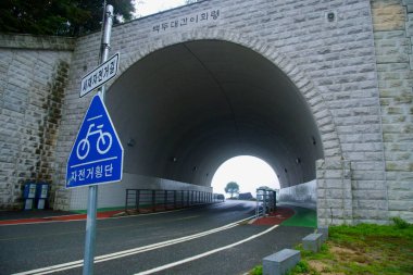 Goesan ilçesindeki Ihwa Geçidi 'nin yakınlarındaki ormanların altından geçen nemli bir dağ yolu, kırmızı bir omuz yolu ve kıvrımları takip eden mavi bir kenar çizgisi var..