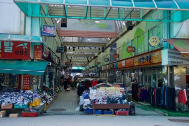 Chuncheon City, Güney Kore 'de, Chuncheon Jungang Marketi' nin kapalı koridorlarında her iki tarafta ayakkabı ve giysi tezgahları var..