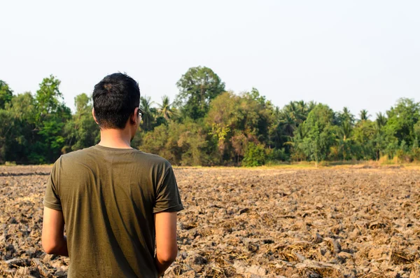 Un hombre mirando tierra estéril —  Fotos de Stock