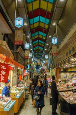 Kyoto, Japan - December 2, 2015: People shopping in Nishiki ichiba market. Nishiki ichiba market  is a famous market in Kyoto, Japan clipart