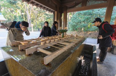Tokyo, Japonya - 26 Ocak 2016: Kimliği belirsiz kişi el ve ağız Temizuya durulayın. Şinto su abdest pavilion temizu bilinen bir tören arıtma ayin için Temizuya olduğunu.