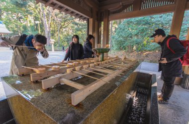 Tokyo, Japonya - 26 Ocak 2016: Kimliği belirsiz kişi el ve ağız Temizuya durulayın. Şinto su abdest pavilion temizu bilinen bir tören arıtma ayin için Temizuya olduğunu.