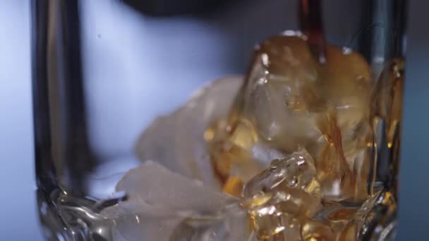 Whisky coulant sur la glace dans le verre 