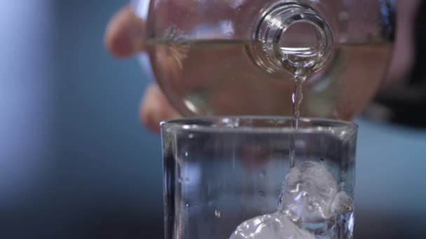 L'eau coulant sur la glace dans le verre d'une bouteille 