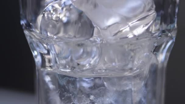 Eau coulant sur la glace dans le verre — Video
